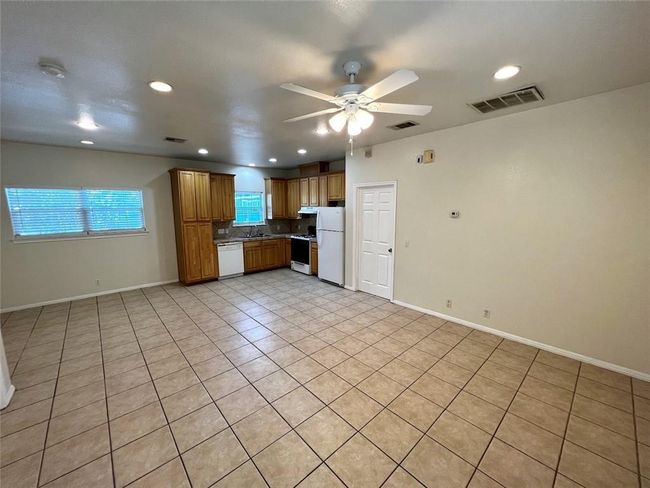 Kitchen featuring white appliances, ceiling fan, backsplash, light tile patterned flooring, and recessed lighting | Image 4