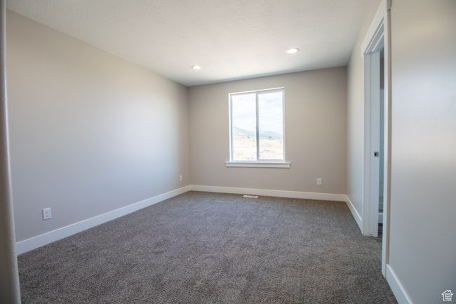 Unfurnished bedroom with baseboards, dark colored carpet, and recessed lighting. *Photo in picture is similar to the home being built | Image 6