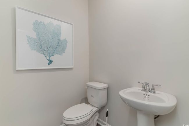 Bathroom with toilet, baseboards, and a sink | Image 5