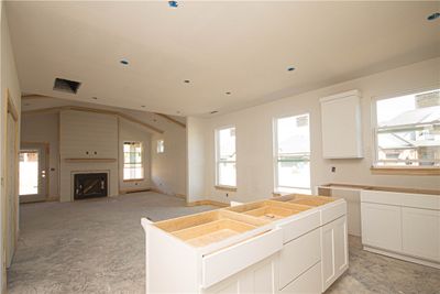 Large windows flood the living room with natural light, creating a warm and welcoming atmosphere. | Image 3