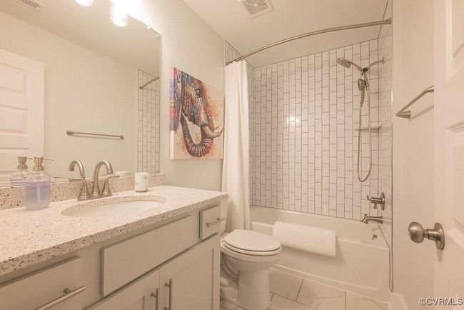 Full bathroom featuring vanity, shower / bathtub combination with curtain, and marble look tiles | Image 40