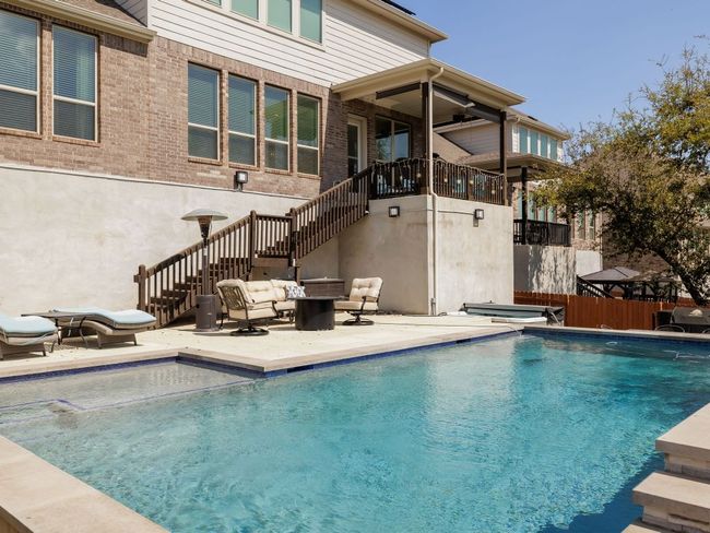 View of pool featuring fence, stairs, a patio, a fenced in pool, and a jacuzzi | Image 32