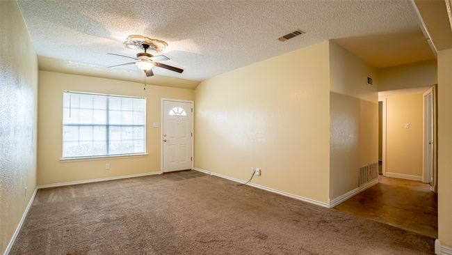 Unfurnished room featuring ceiling fan, carpet floors, a textured ceiling, and baseboards | Image 5