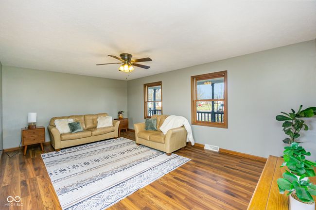 living area with baseboards, ceiling fan, visible vents, and wood finished floors | Image 10