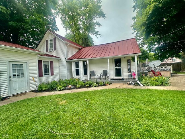 traditional-style house featuring a porch, a metal roof, and a front yard | Image 7
