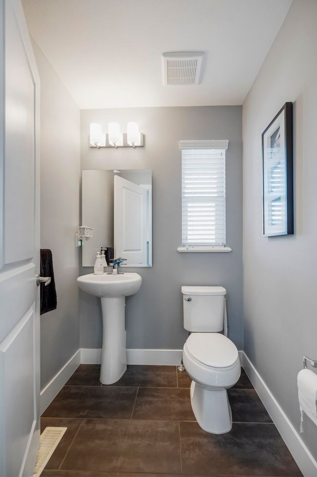 Half bathroom with visible vents, toilet, baseboards, and a sink | Image 18