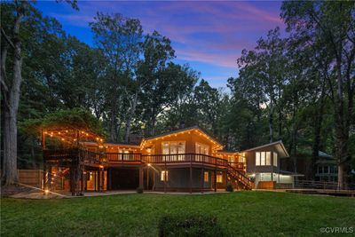 Back house at dusk featuring a deck and a yard | Image 3