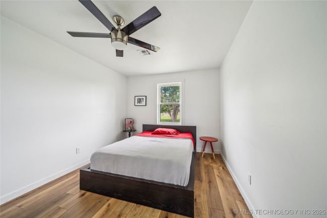 Bedroom featuring hardwood / wood-style flooring, baseboards, and ceiling fan | Image 21