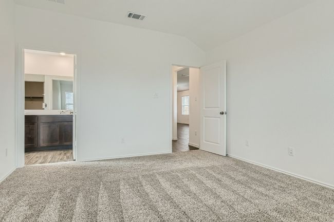 Unfurnished bedroom featuring carpet flooring, baseboards, vaulted ceiling, and connected bathroom | Image 11