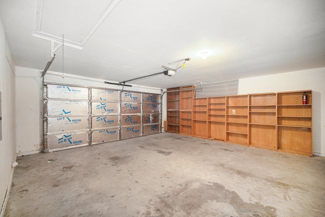 Two car garage with shelving and insulated garage door. Automatic garage door opener with remote. Attic access. | Image 22