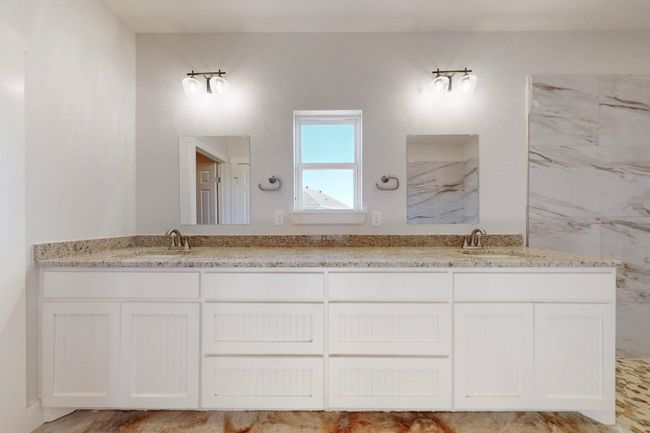 Full bathroom with double vanity, a sink, and a marble finish shower | Image 26