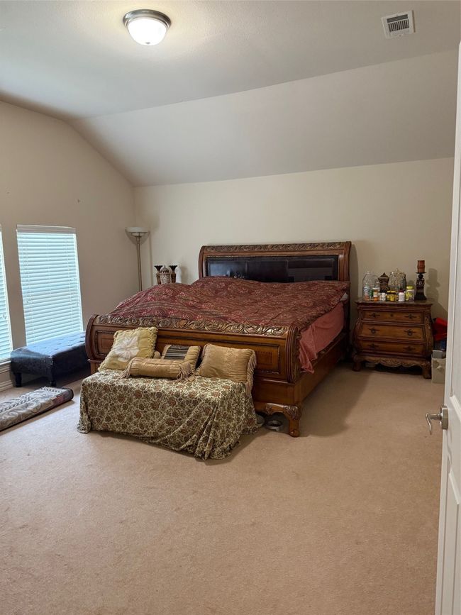Bedroom with light carpet and lofted ceiling | Image 31