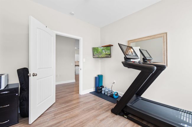 Workout room with light wood-style floors and baseboards | Image 30