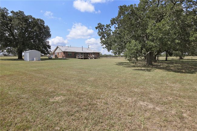View of green lawn featuring a storage shed | Image 11