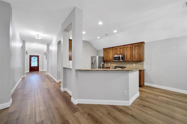 A wrap around breakfast bar keeps the kitchen open to the family room and offers extra seating and serving space. | Image 10