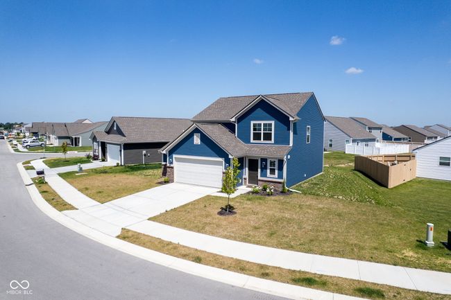 traditional-style home featuring concrete driveway, a front lawn, a garage, and a residential view | Image 44