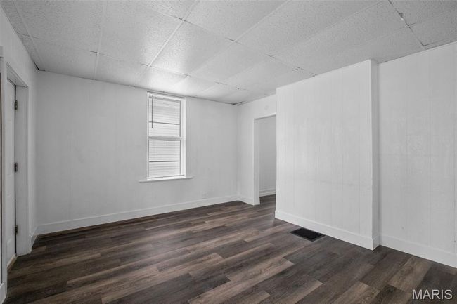 Unfurnished room featuring a drop ceiling and dark wood-style floors | Image 5