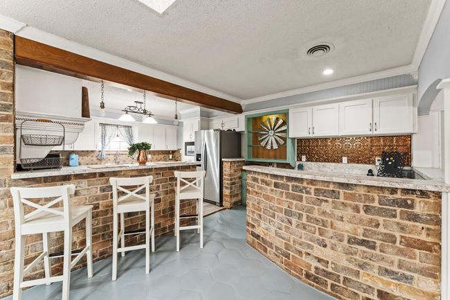 The dining room includes a brick accent wall and built-in wet bar! | Image 8