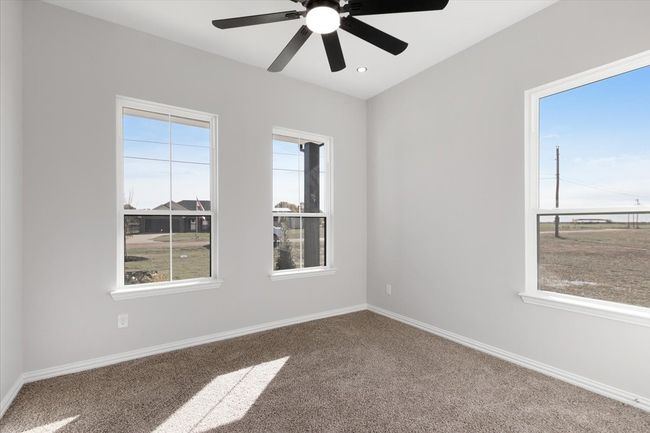 Carpeted empty room featuring baseboards and ceiling fan | Image 8