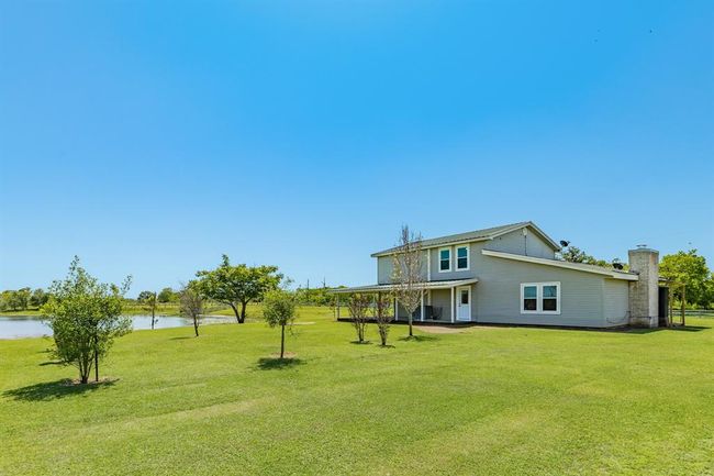 View of the fruit trees back toward the house. The door that you see on this side is the one that goes into the Dining Area of the house. | Image 15