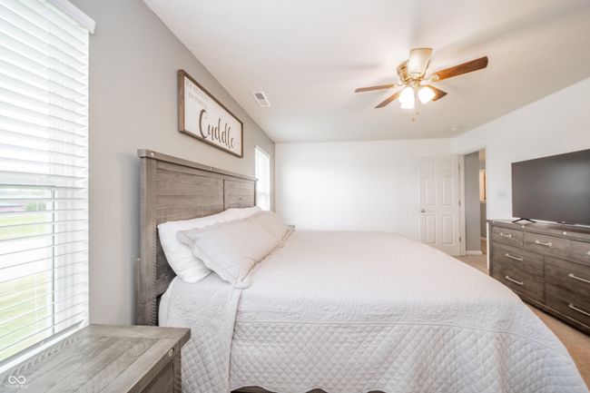 bedroom featuring light colored carpet, a ceiling fan, and baseboards | Image 33