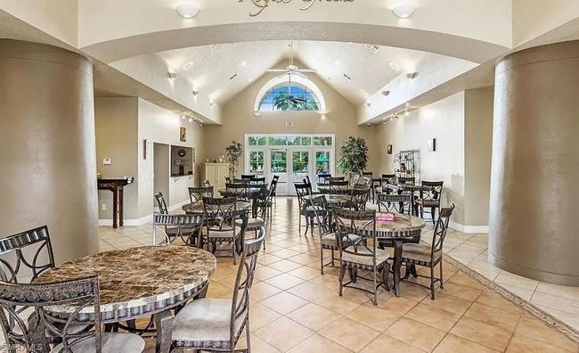Dining area with light tile patterned floors, a ceiling fan, high vaulted ceiling, and baseboards | Image 22