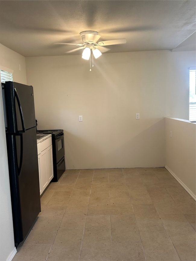 Kitchen with refrigerator, stove, white cabinetry, and a ceiling fan | Image 17