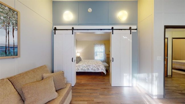 Bedroom with a barn door and wood finished floors | Image 19