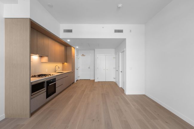 Kitchen with wall oven, light countertops, light wood-style floors, and modern cabinets | Image 7