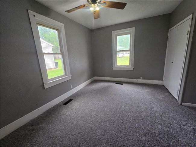 Spare room featuring plenty of natural light, a ceiling fan, carpet flooring, and baseboards | Image 20