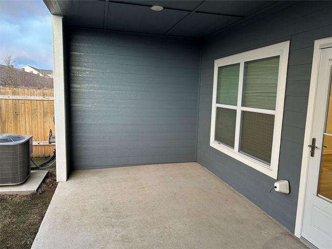 View of patio with cooling unit and fence | Image 5