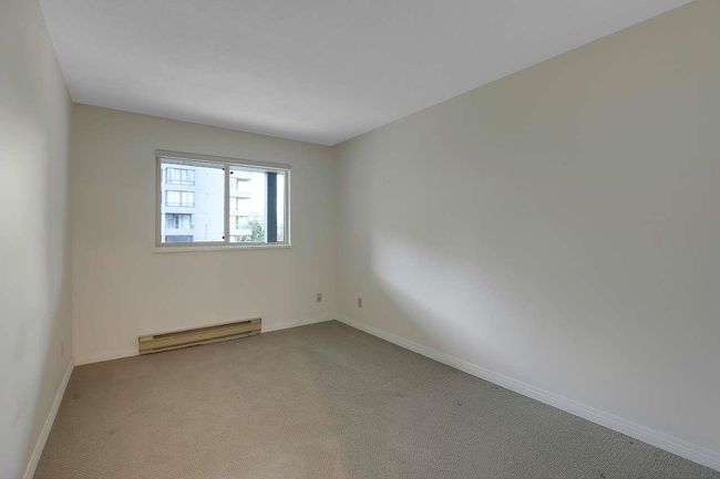Carpeted spare room featuring a baseboard radiator and baseboards | Image 21