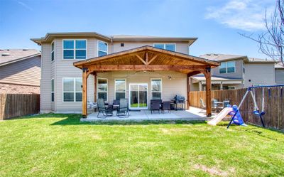 Backyard featuring Cedar covered patio with fan and accent lights | Image 2