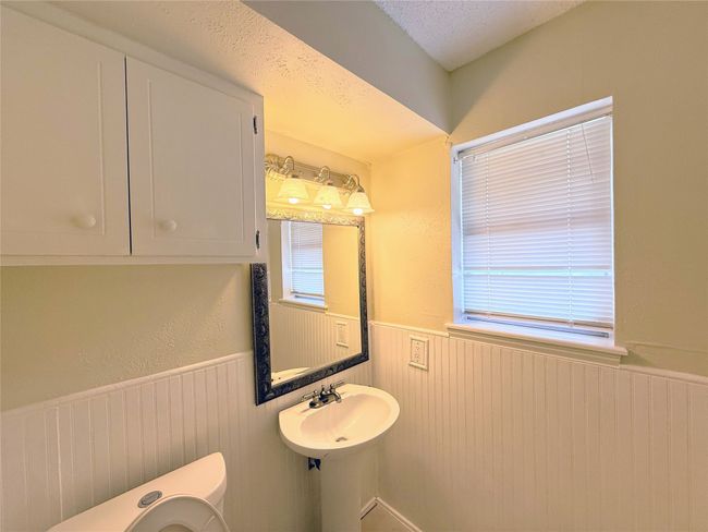 Bathroom with a wainscoted wall and healthy amount of natural light | Image 13