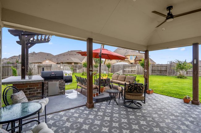 Massive, wrap-around back patio with high, vaulted ceiling and charming, custom painted concrete | Image 28