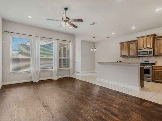 Kitchen with recessed lighting, decorative backsplash, ceiling fan, stainless steel appliances, and light wood-style flooring | Image 14