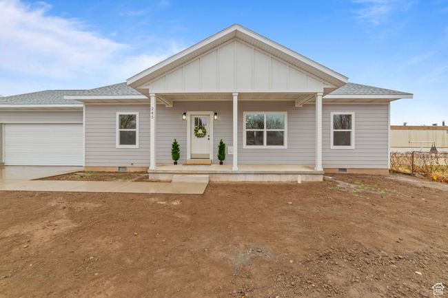 View of front of property featuring covered porch, concrete driveway, crawl space, and a garage | Image 4