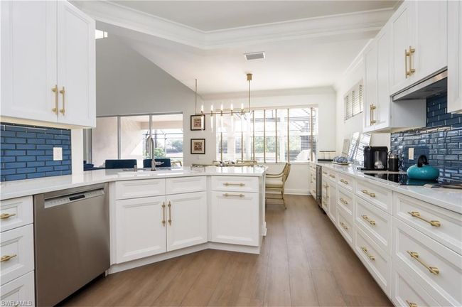 Kitchen with dishwasher, ventilation hood, a peninsula, light wood-style flooring, and white cabinets | Image 8