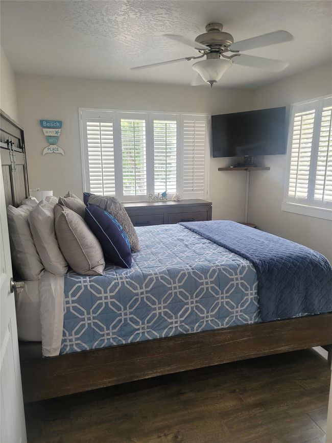 Bedroom featuring ceiling fan, hardwood / wood-style floors, and a textured ceiling | Image 15