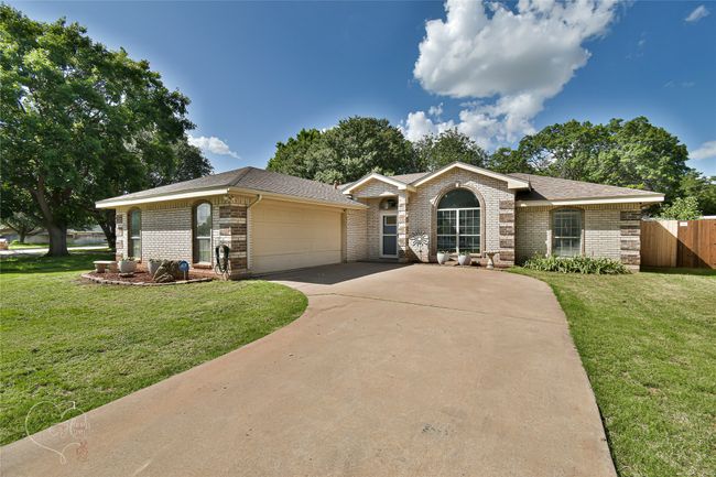 Ranch-style home featuring brick siding, driveway, an attached garage, and roof with shingles | Image 38