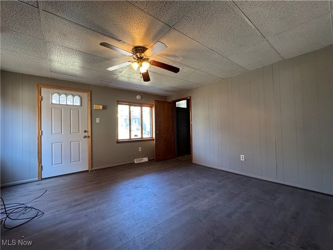 Entrance foyer featuring a ceiling fan, visible vents, a drop ceiling, and wood finished floors | Image 22
