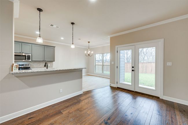 Kitchen featuring stainless steel appliances, tasteful backsplash, baseboards, dark wood-style flooring, and ornamental molding | Image 9