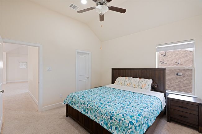 Bedroom with light carpet, ceiling fan, and high vaulted ceiling | Image 32