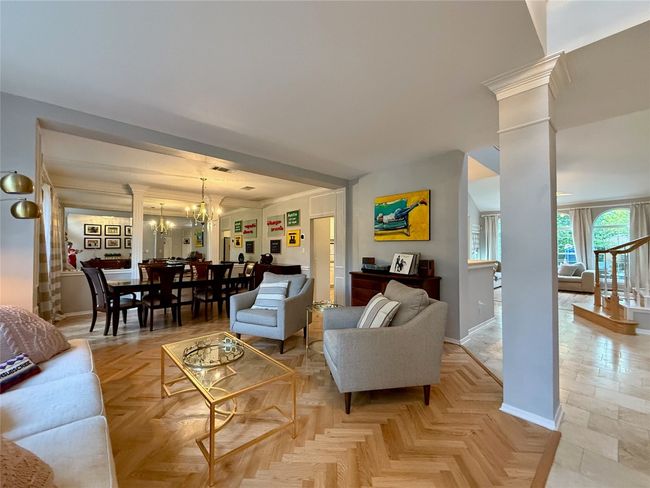 Living area featuring baseboards, decorative columns, and a notable chandelier | Image 4