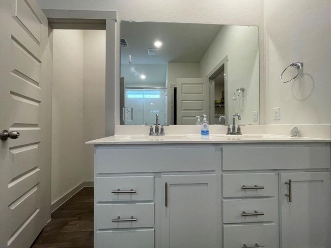 Full bath with double vanity, wood finished floors, and baseboards | Image 14