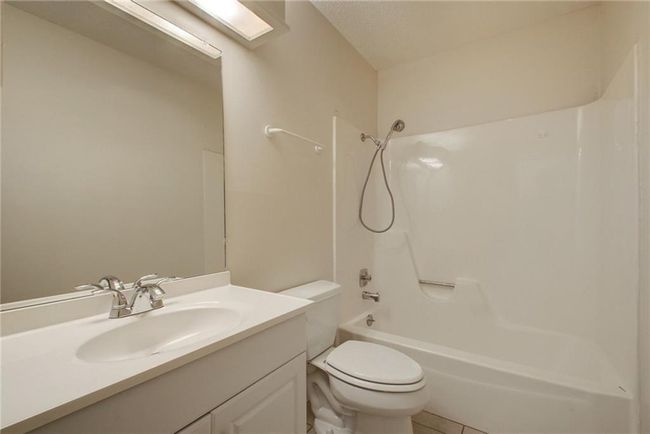 Full bath with washtub / shower combination, vanity, toilet, and tile patterned flooring | Image 27