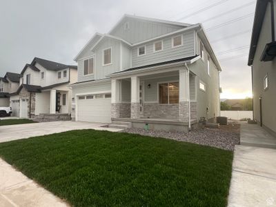 View of front facade with a front lawn, a garage, covered porch, and central AC unit | Image 2