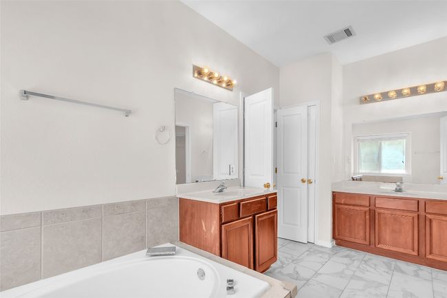 Bathroom with a bath, two vanities, and light marble finish floors | Image 16