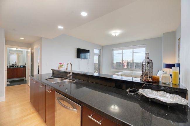 Kitchen featuring dishwasher, light wood finished floors, dark stone counters, recessed lighting, and open floor plan | Image 12