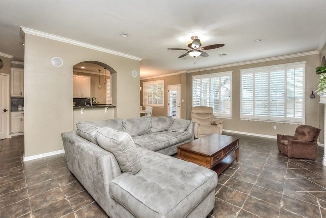 Another view of the family room features the wall of windows with custom plantation shutters that bathe the room with natural sunlight. | Image 12